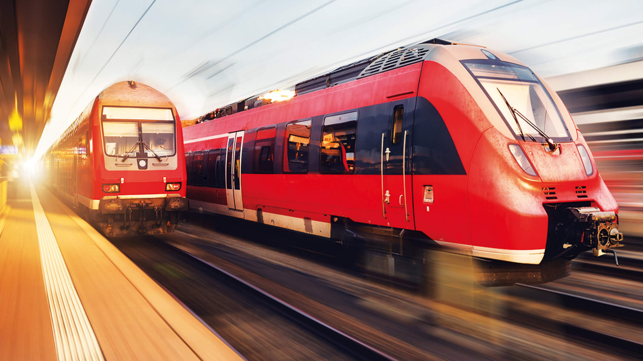 Regionalzüge der Deutschen Bahn fahren am Bahnhof vorbei