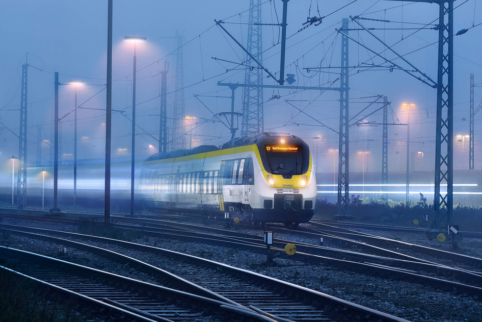 Gelb-weiße Bahn der SWEG fährt bei Nacht.