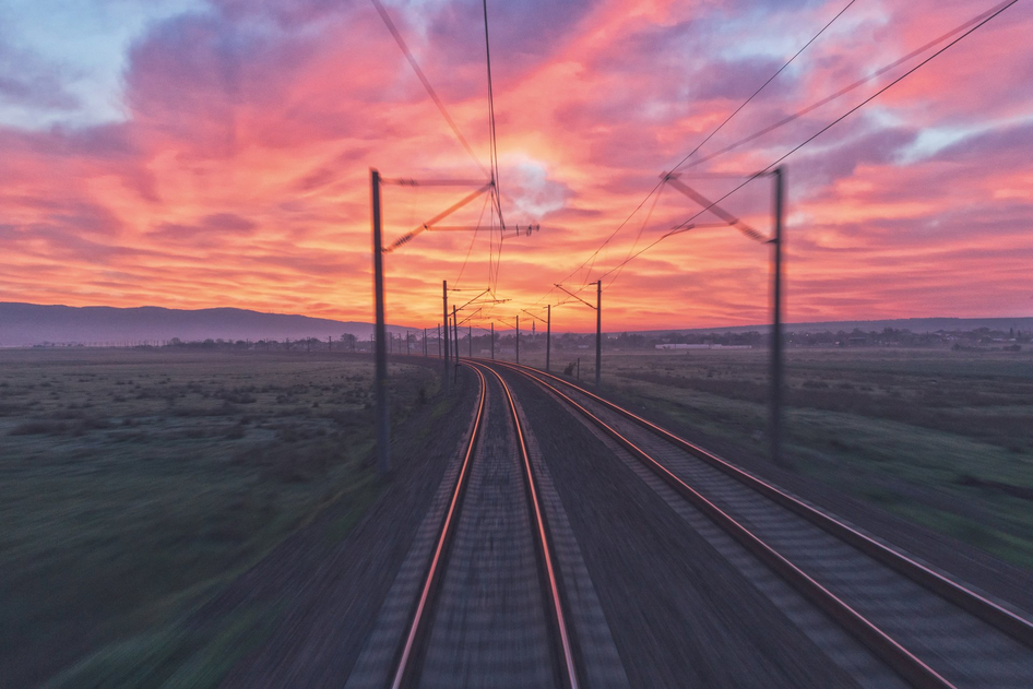 Trasse vor lila-pink-gelbem Sonnenuntergang