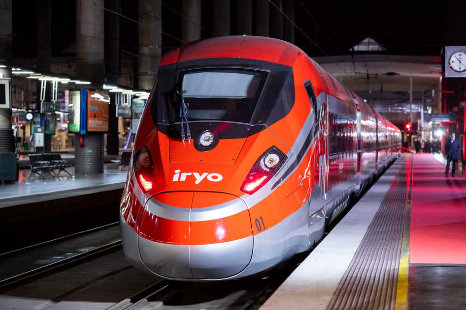 Ein Foto eines rot-silbenen iryo-Zuges von vorne, der am Bahnhofsgleis steht.