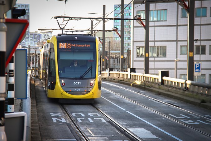 Eine gelb-schwarze Straßenbahn der Provinz Utrecht steht an einer Station.