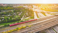 Aerial einer roten S-Bahn von DSB, die vor untergehender Sonne durch Kopenhagen fährt.
