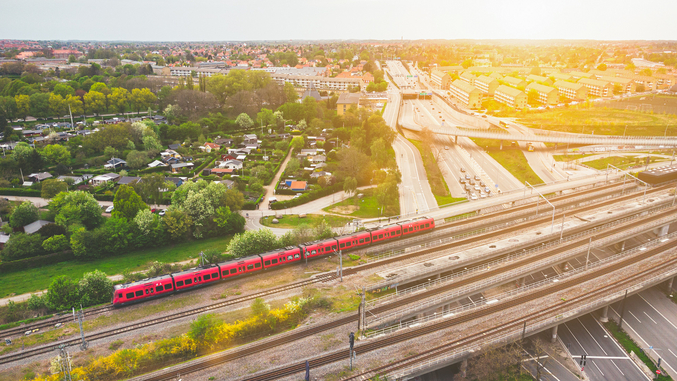 Aerial einer roten S-Bahn von DSB, die vor untergehender Sonne durch Kopenhagen fährt.